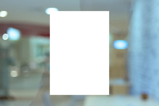 Mockup A4 white paper or white promotion poster displayed on the front of bright office interior, - stock photo