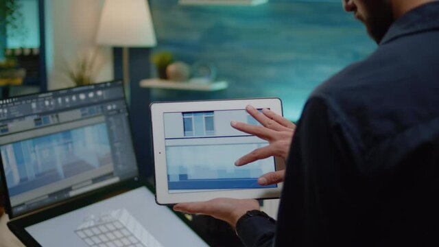 Architect Holding Digital Tablet With Building Model For Construction Layout In Office. Man Engineer Working On Blueprint Plan With Touch Screen Monitor And Device For Architectural Project