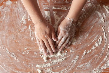 Fototapeta premium women hands stained with flour background wooden table, cooking dough. concept cooking, recipes, proper nutrition