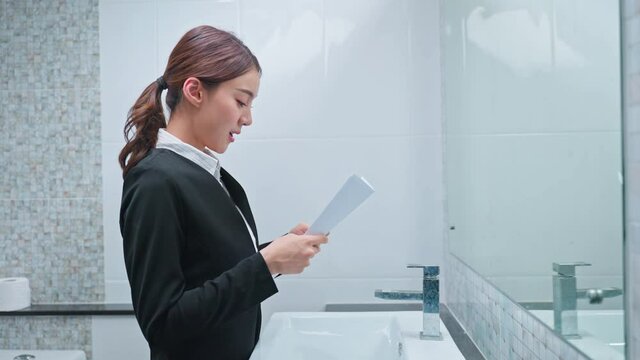Asian applicant prepare for job interview in front of mirror at home.