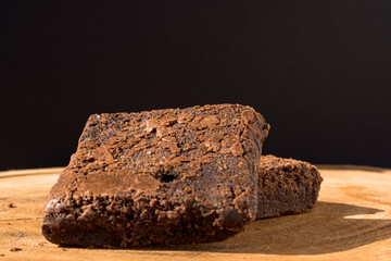 Pieces of fresh brownie on wooden background. Delicious chocolate pie. Macro Close-up. Selective focus.