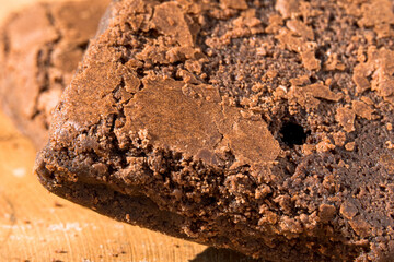 Pieces of fresh brownie on wooden background. Delicious chocolate pie. Macro Close-up. Selective focus.