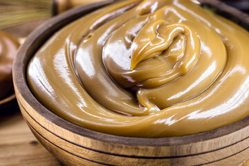 homemade dulce de leche, sour cream or doughy caramel in a rustic wooden bowl