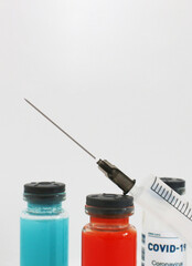 Three ampoules with a vaccine against diseases on a light background.