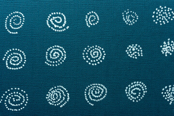 pattern with circles or spirals composed of dots on blue paper