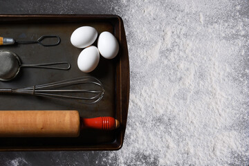 Baking Concept. Top view of a ball of raw bread dough on a baking sheet with a wood rolling pin,...