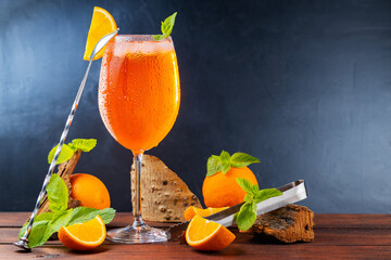 Cocktail aperol spritz and bar tools. Italian aperol spritz cocktail and a sliced orange on a dark...