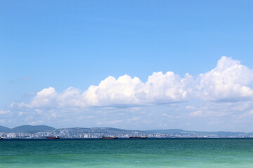 Seascape on the shore with tourists resting in hot sunny