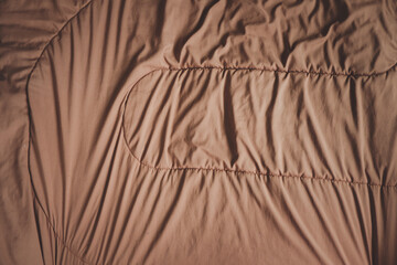 Fototapeta na wymiar Brown blanket, soft and warm fabric crumpled in folds