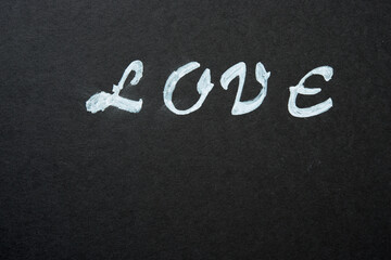 the word "love" stencilled in white on black paper