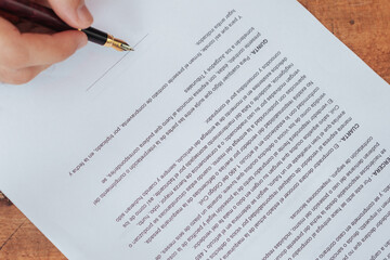 Top view of a contract and hands with pen before signing. Cenital shoot. security, legality and contracting