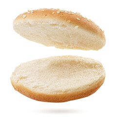 Burger bun cut into two halves flies on a white background. Isolated