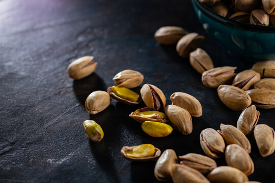 Roasted pistachios nuts on dark background. Pistachio - healthy vegetarian protein nutritious food. Healthy snack. Copy space. Top view