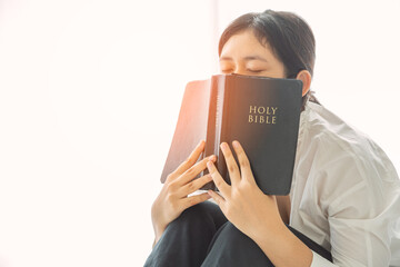 Christian teenage girl holds bible in her hands.
