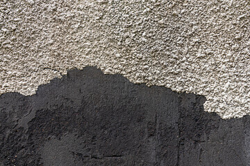 Black and gray wall with rough plaster. Cement, textured concrete background.