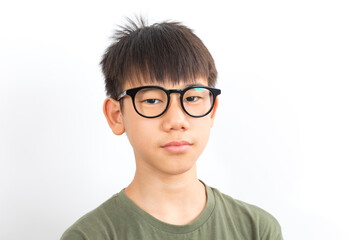 Fototapeta premium Frowning asian schoolboy wear glasses with serious look standing on white background.