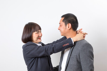 Asians executive businessman and businesswoman smile and hugging standing on white background.