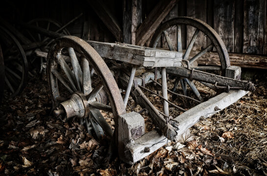 decayed old wooden wagon with wooden wheels in a barn