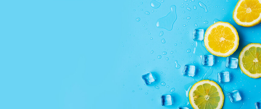 juicy fresh yellow lemon slices and ice cubes on a blue background. Top view, flat lay. Banner
