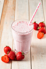 Fresh milkshake with strawberries. Summer drink with berries in a glass on wooden background.