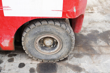 Forklift wheel on granite paving stones stained with machine oil. Close up