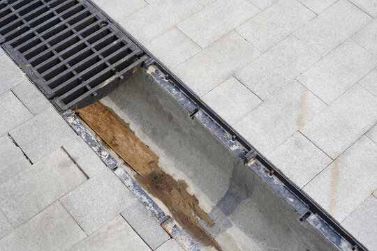 Drainage system made of concrete and metal grate. Construction of roads and sidewalks. Close-up