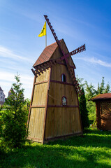 Old large wooden hand-made mill with blades on a summer day