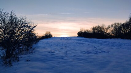 Fototapeta na wymiar Winter sunset over hill
