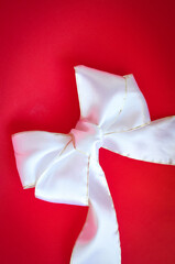 White bow and ribbon on red background 