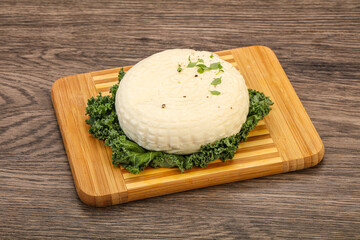 Caucasian suluguni round cheese piece