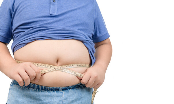 Obese boy measures his fat belly with a measuring tape isolated on white