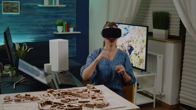 Architect using vr glasses for building design with blueprint plan on table. Construction engineer working with virtual reality headset for development project and maquette model.