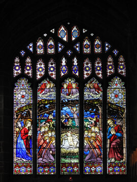CHESTER, CHESHIRE WEST AND CHESTER, UK – JULY 11, 2019: Large window of stained glass inside the historic Chester Cathedral, depicting the Christmas nativity scene of baby Jesus in his manger