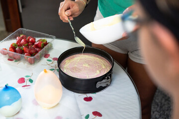 Creative cooking day: mother and daughter baking an original white chocolate cake at home.