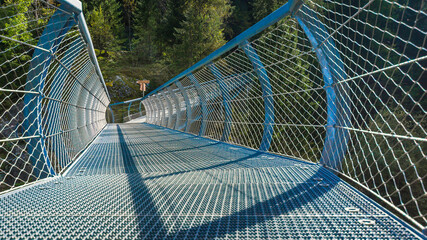Moderne Fußgängerbrücke aus Stahlgeflecht über die Passer in Südtirol