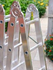 New aluminium multipurpose hinged ladder standing outdoors