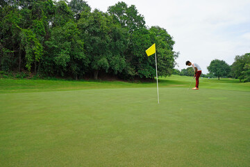 Obraz premium Golfers are putting golf in the evening golf course golf backglound. Golfer hitting golf ball.