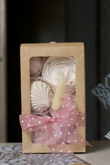 Homemade marshmallows in craft packaging. Zephyr in the form of a rose. Decorated with ribbon and lagurus. Close-up shot.