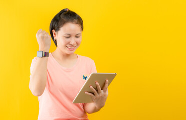 young woman enjoying online shopping happily at home against yellow background