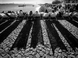 Sunset watchers on the Lisbon waterfront. Long shadows. Portugal.