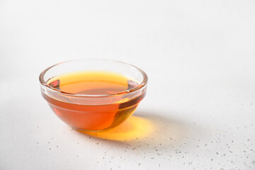 Jerusalem artichoke syrup in glass bowl on white background. Close up. Sugar substitute for raw vegan desserts.
