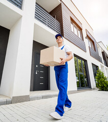 Young delivery man hold a cardboard box in his hands