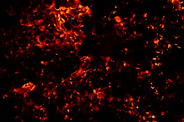 Fototapeta na wymiar background of burning and glowing hot coals. smoldering embers of fire. flicker of burning coals at night