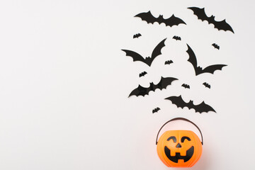 Overhead photo of pile of big and mini black bats and basket with sweets as pumpkin isolated on the white background with blank space