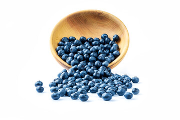 Fresh blueberries spilled from wooden bowl on white surface. Healthy and dietary food concept. Blueberry is an antioxidant
