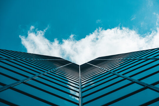 Dramatic perspective on high-rise skyscraper office building with cloudy blue sky