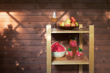 White wine, fruits, watermelon and watermelon lemonade stand on wooden shelves