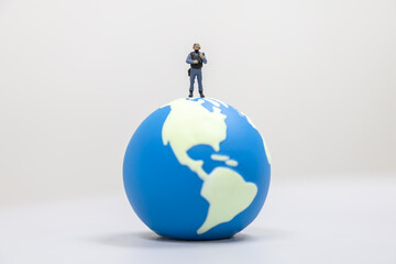 Global and Security Concept. Soldier or Police miniature figure people with machine gun standing on mini world ball.