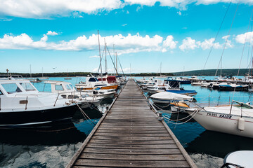 Fototapeta na wymiar Bootssteg mit Segelbooten und blaubem Himmel 