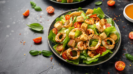Grilled squid or calamari and shrimp salad with garlic croutons and cherry tomatoes. healthy food.